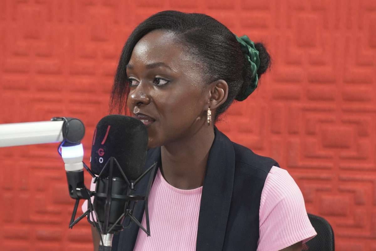 A woman speaking into a microphone in a radio studio.